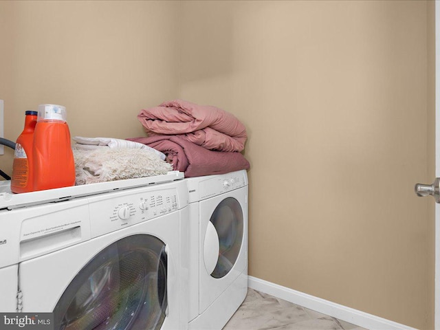 washroom featuring laundry area, baseboards, marble finish floor, and washer and dryer