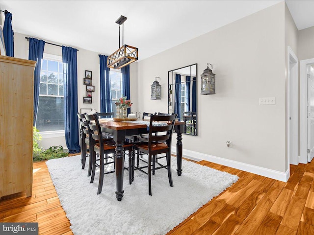 dining room with wood-type flooring and baseboards