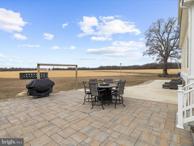 view of patio / terrace featuring outdoor dining space, a grill, and a rural view