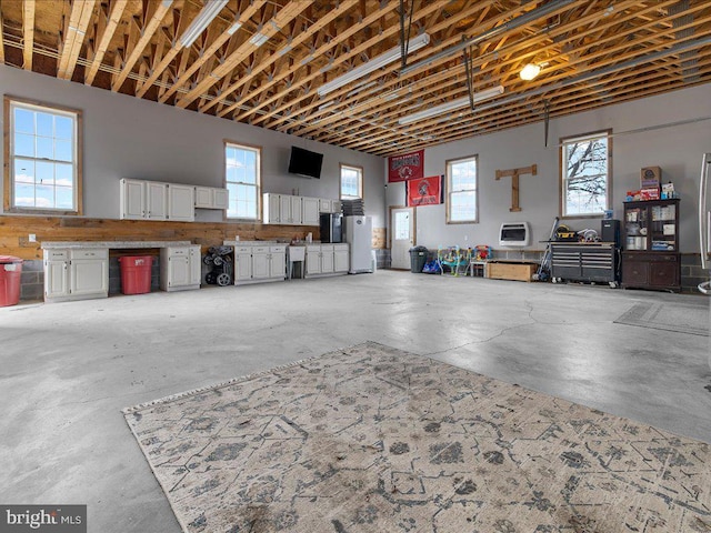 garage featuring heating unit and freestanding refrigerator