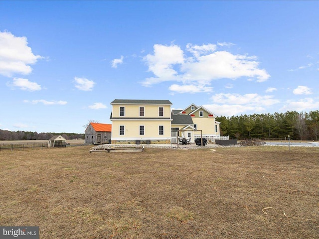 rear view of house featuring a patio area, fence, and a yard