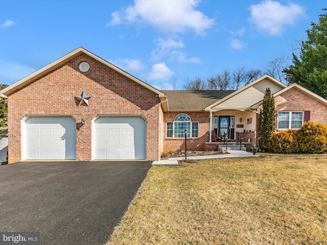 ranch-style home featuring driveway, a garage, brick siding, roof with shingles, and a front yard