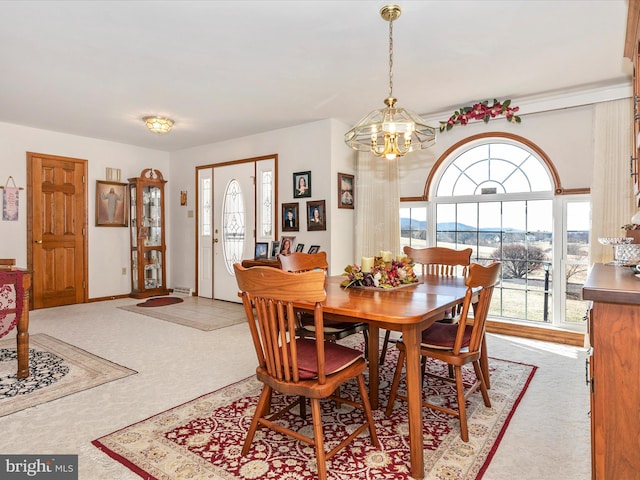 carpeted dining room featuring an inviting chandelier