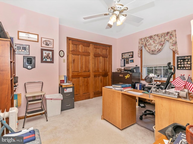 carpeted office space featuring ceiling fan