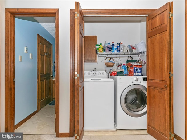 laundry area with cabinet space, independent washer and dryer, and baseboards