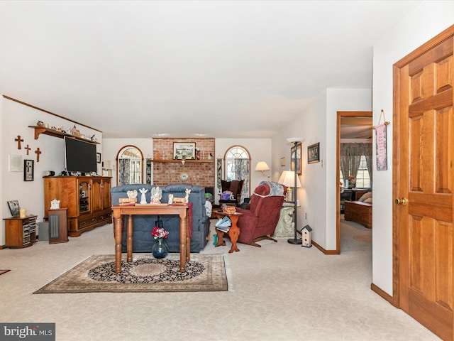 carpeted living area featuring baseboards