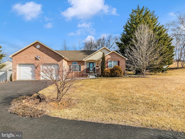 ranch-style house featuring a garage, a front yard, brick siding, and driveway