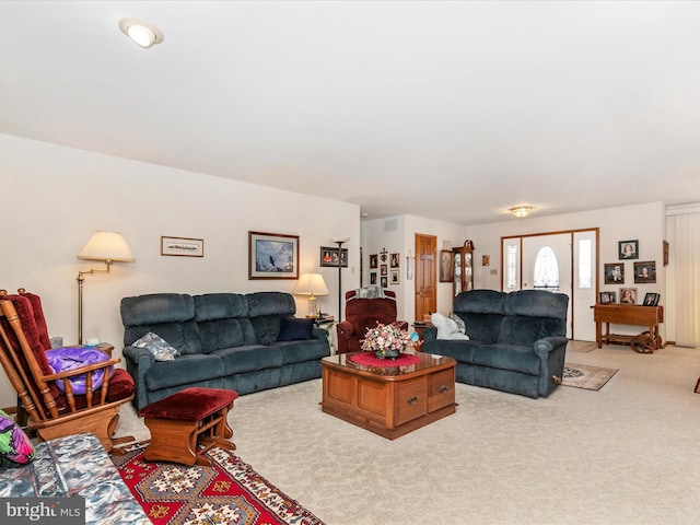 living area with visible vents and light colored carpet