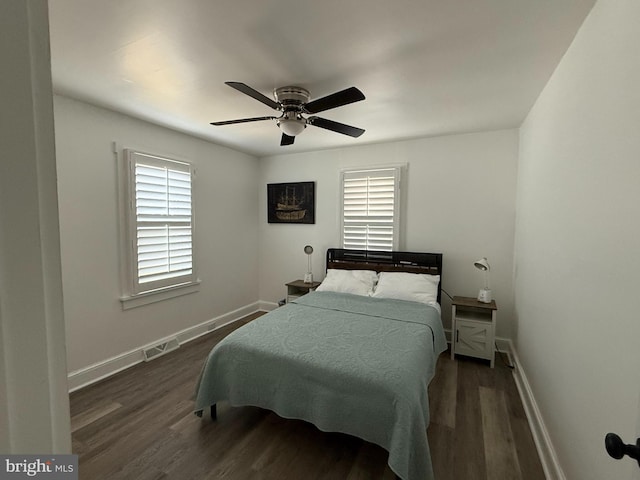 bedroom with baseboards, a ceiling fan, wood finished floors, and visible vents