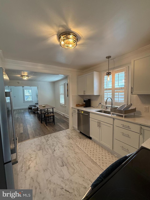 kitchen featuring a sink, appliances with stainless steel finishes, ornamental molding, and white cabinetry