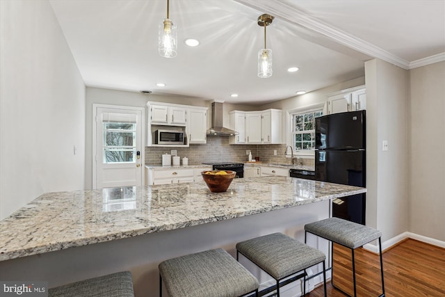 kitchen with dark wood-style flooring, a sink, black appliances, wall chimney exhaust hood, and backsplash