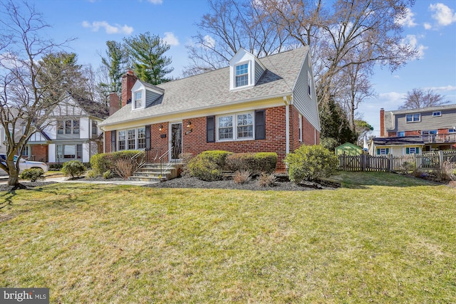 cape cod house with a front lawn, fence, roof with shingles, brick siding, and a chimney