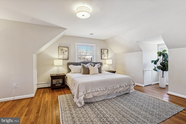 bedroom featuring vaulted ceiling, wood finished floors, baseboards, and baseboard heating