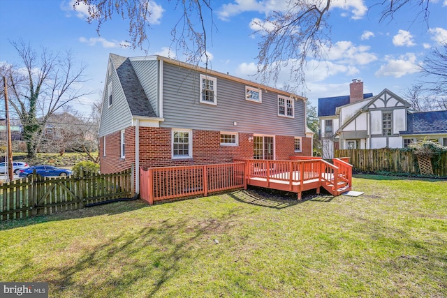 back of house with a yard, a fenced backyard, brick siding, and a wooden deck