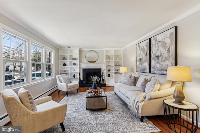 living area with a baseboard heating unit, wood finished floors, and ornamental molding