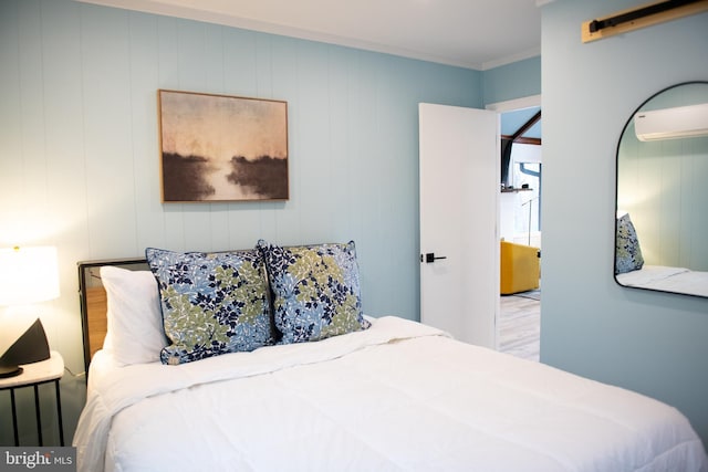 bedroom featuring wood finished floors and an AC wall unit