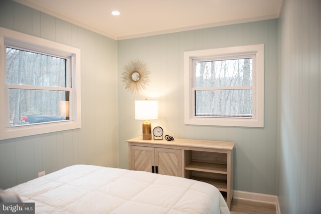 bedroom with recessed lighting, multiple windows, baseboards, and wood finished floors