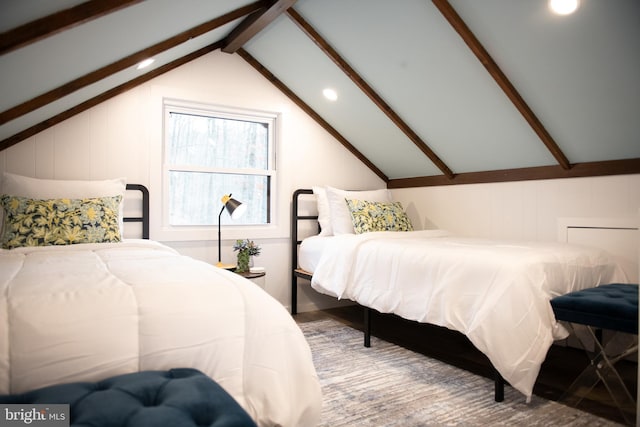 bedroom with vaulted ceiling with beams and wood finished floors