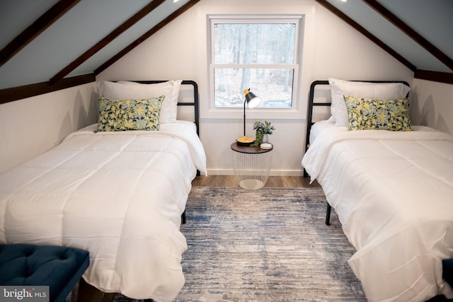 bedroom with vaulted ceiling and wood finished floors