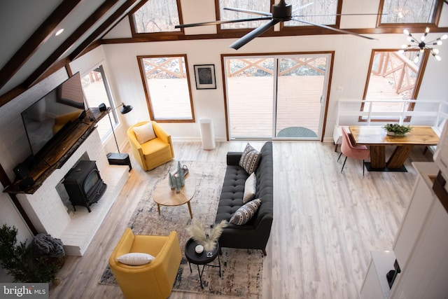 living area featuring high vaulted ceiling, beamed ceiling, wood finished floors, and baseboards