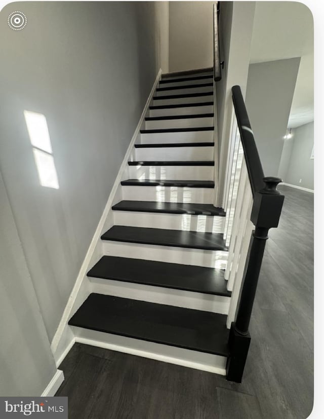 staircase with baseboards and wood finished floors