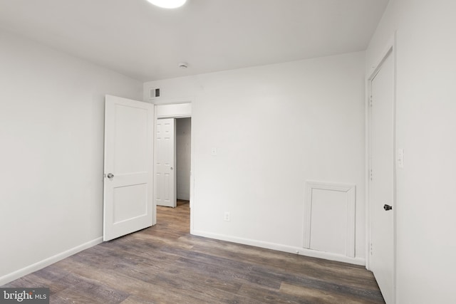 unfurnished bedroom with visible vents, baseboards, and wood finished floors