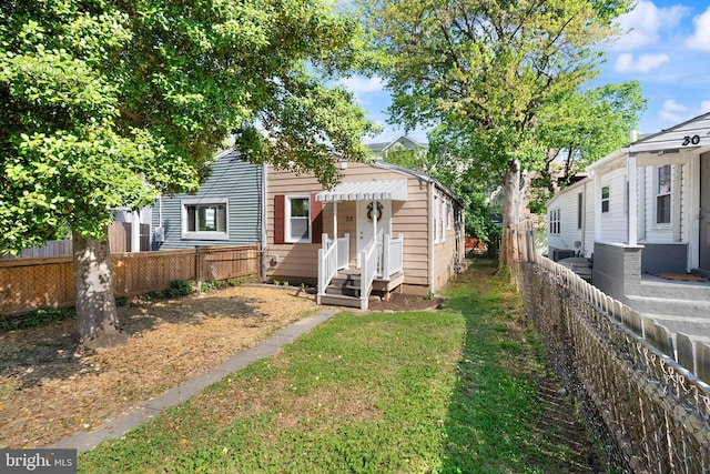 view of front facade with fence and a front lawn