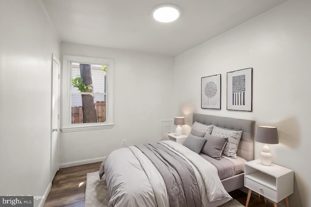 bedroom featuring baseboards and wood finished floors