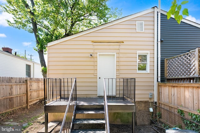 rear view of house with a wooden deck and a fenced backyard