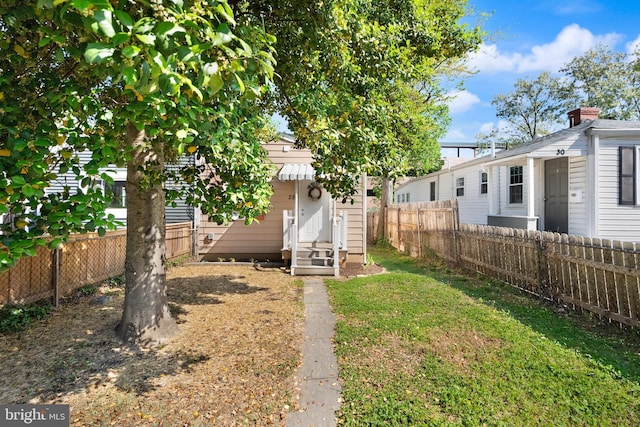 view of yard featuring entry steps and a fenced backyard