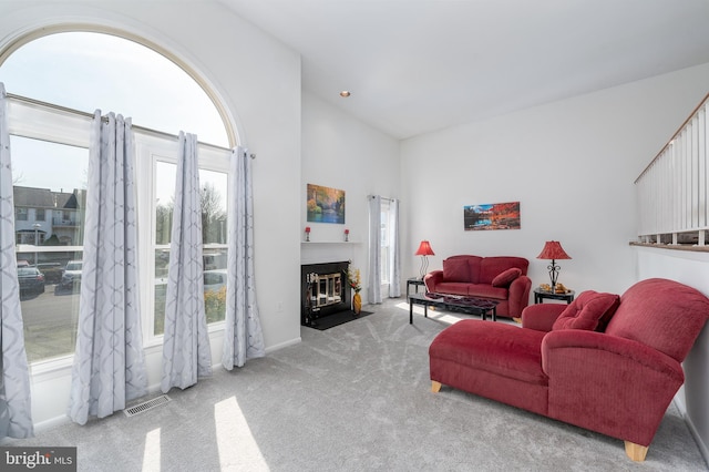 living room with visible vents, baseboards, a fireplace with flush hearth, carpet floors, and recessed lighting