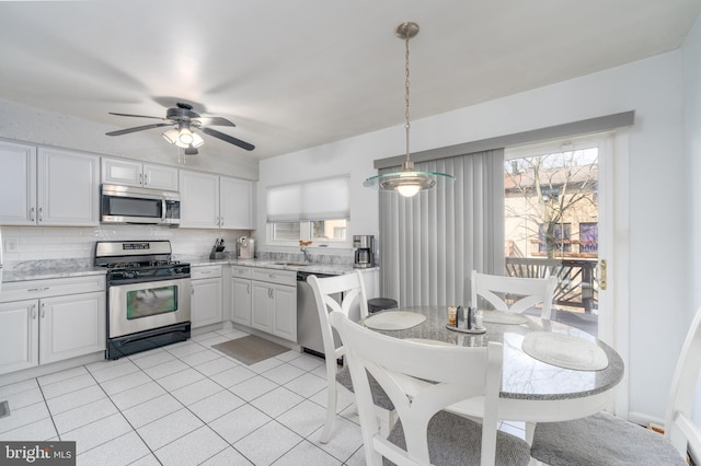 kitchen featuring stainless steel appliances, light tile patterned flooring, decorative backsplash, and a healthy amount of sunlight