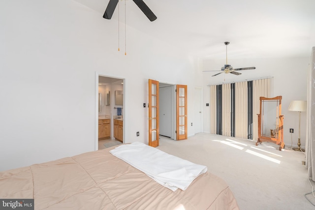 bedroom with ensuite bathroom, high vaulted ceiling, a ceiling fan, and light colored carpet