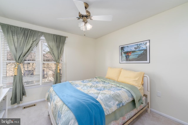 carpeted bedroom with baseboards, visible vents, and a ceiling fan