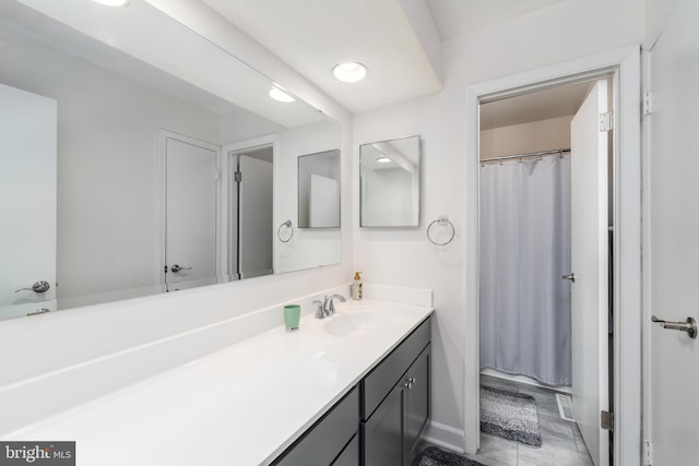 full bath featuring vanity and baseboards