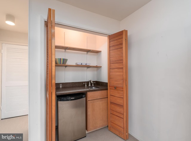 bar with stainless steel dishwasher and a sink