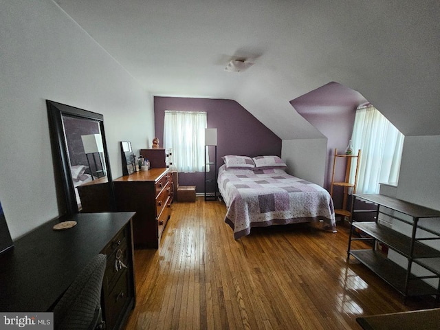 bedroom with dark wood-style floors and vaulted ceiling