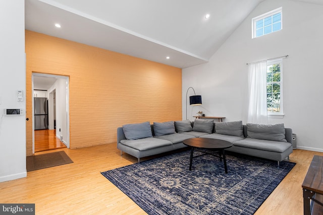 living area featuring high vaulted ceiling, recessed lighting, baseboards, and wood finished floors