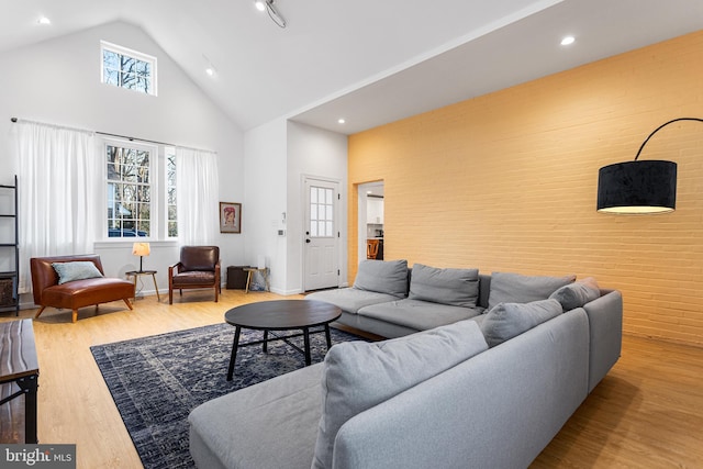 living area with high vaulted ceiling, recessed lighting, baseboards, and wood finished floors