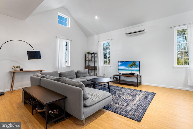 living room with high vaulted ceiling, a wall mounted AC, wood finished floors, and baseboards