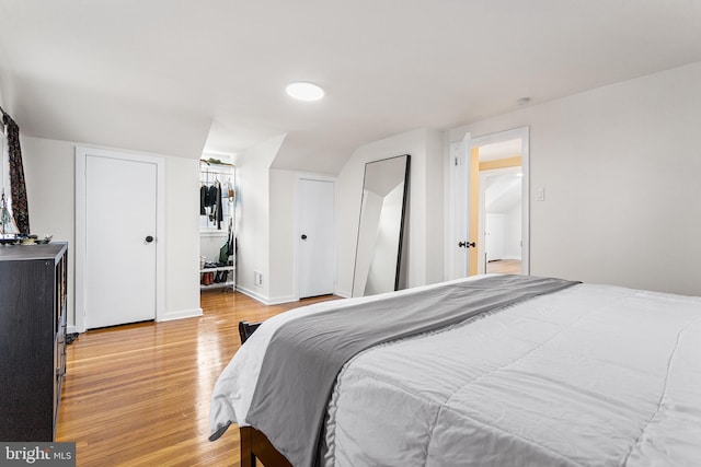 bedroom with light wood-type flooring and baseboards