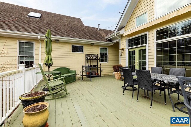 deck with french doors and outdoor dining area