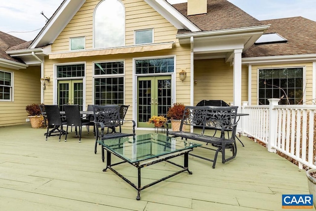 wooden terrace with outdoor dining area and french doors