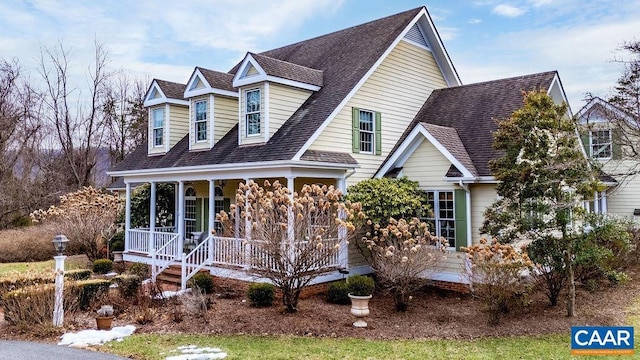 cape cod-style house with covered porch and a shingled roof