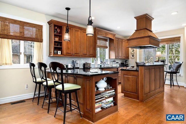 kitchen featuring open shelves, visible vents, dark countertops, and a center island