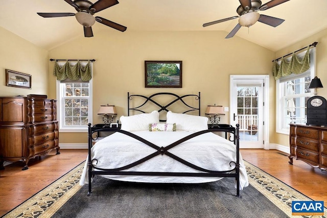 bedroom featuring lofted ceiling, access to exterior, wood finished floors, baseboards, and ceiling fan