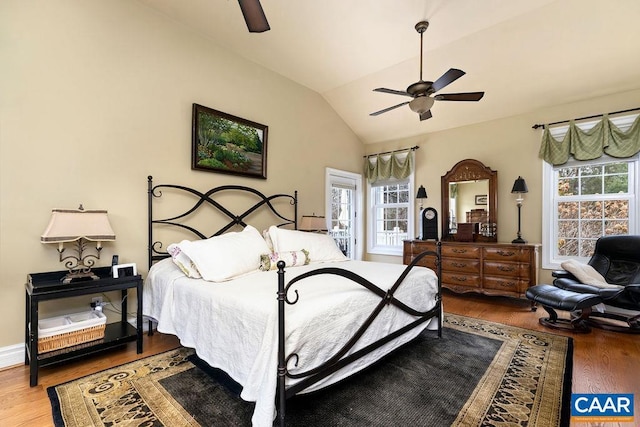 bedroom with ceiling fan, wood finished floors, and vaulted ceiling