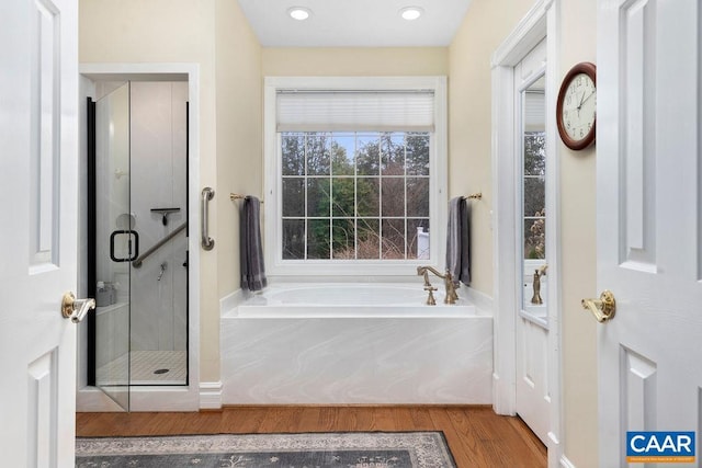 full bathroom featuring recessed lighting, wood finished floors, a garden tub, and a stall shower