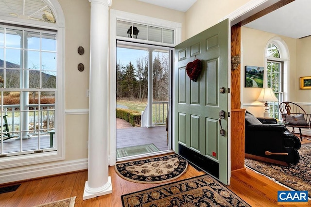 entryway with visible vents, baseboards, ornate columns, and wood finished floors