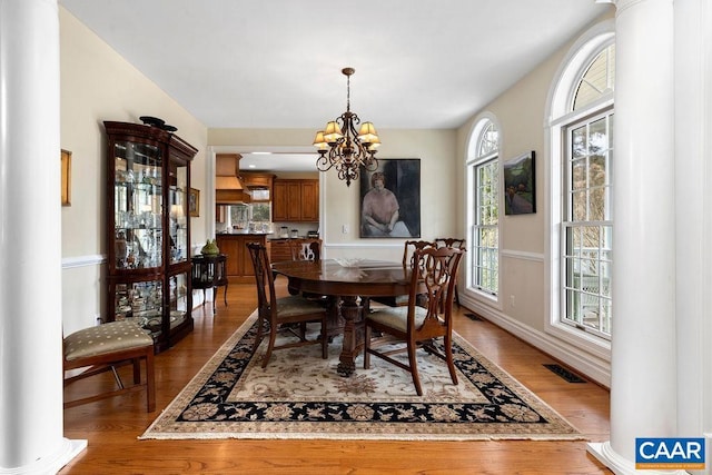 dining room with visible vents, baseboards, an inviting chandelier, and wood finished floors